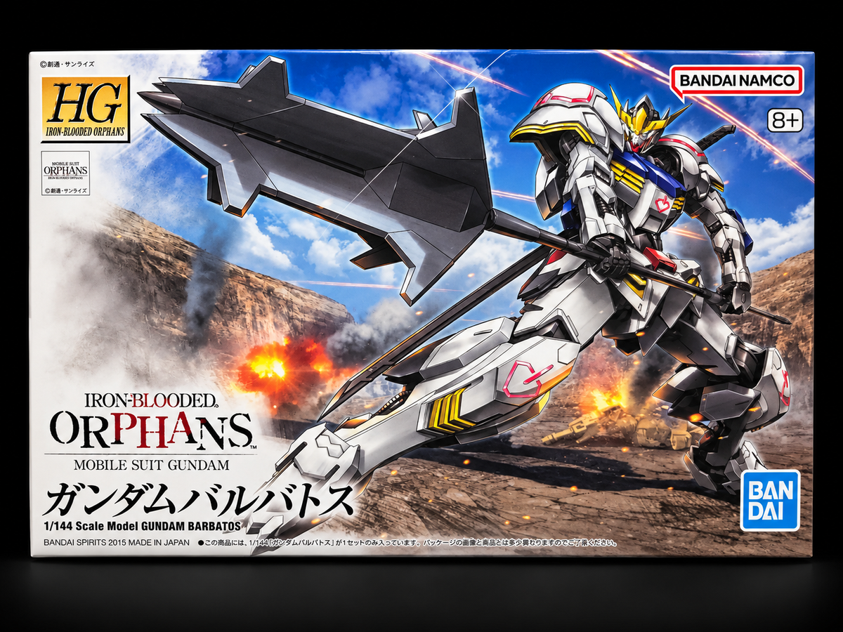 Box art for the HG High Grade Gundam Barbatos model kit, featuring a white and gray Gundam with a large dark gray weapon, set against a battle scene with explosions and a blue sky. Visible brands include Bandai and Namco.
