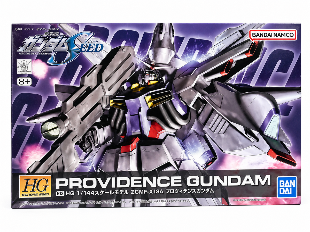 Front of a Gundam model kit box featuring the Providence Gundam mecha in silver, black, and red against a purple comic-style background. Visible branding includes Bandai Namco, HG, and Gundam.