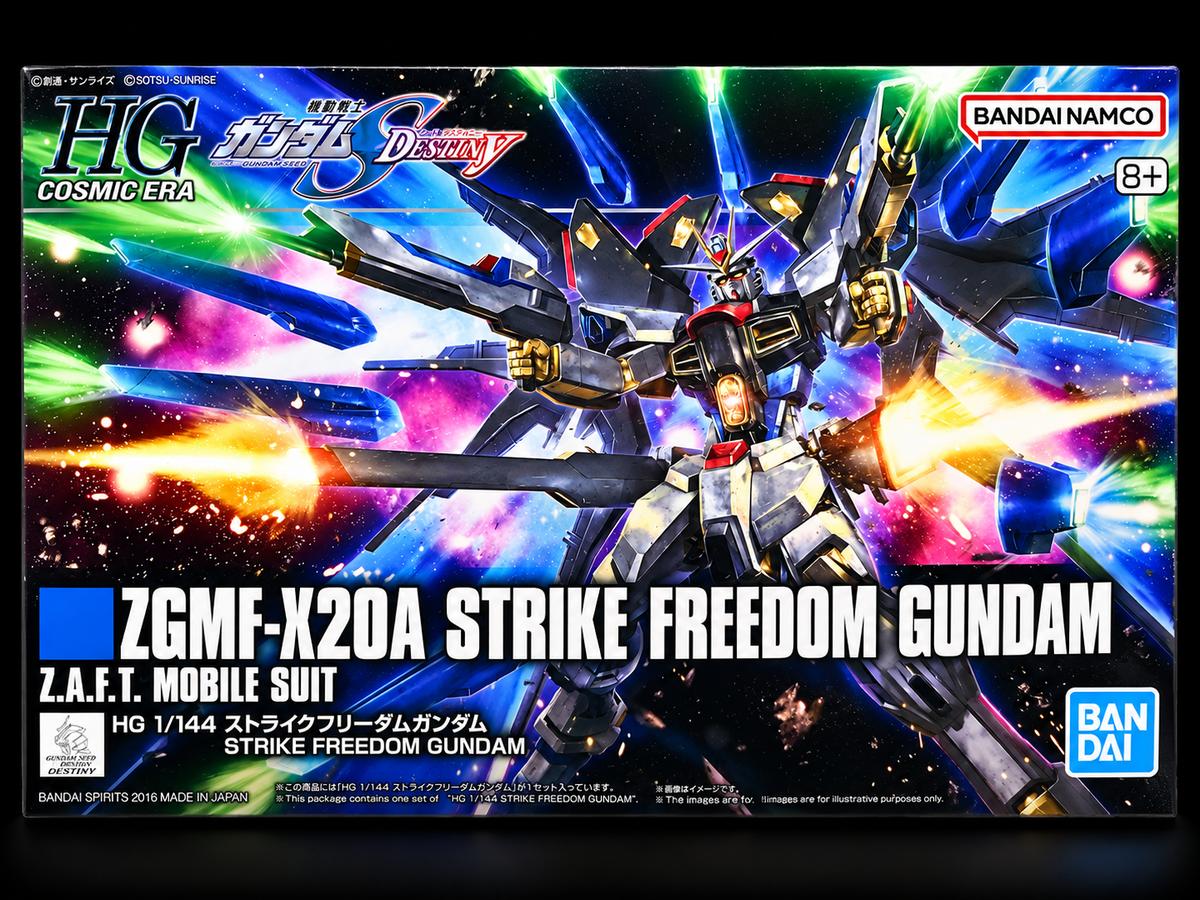 Front packaging artwork for a Bandai Namco HG Cosmic Era ZGMF-X20A Strike Freedom Gundam model kit, showing a colorful sci-fi mecha on a space background with bright laser effects and product text.