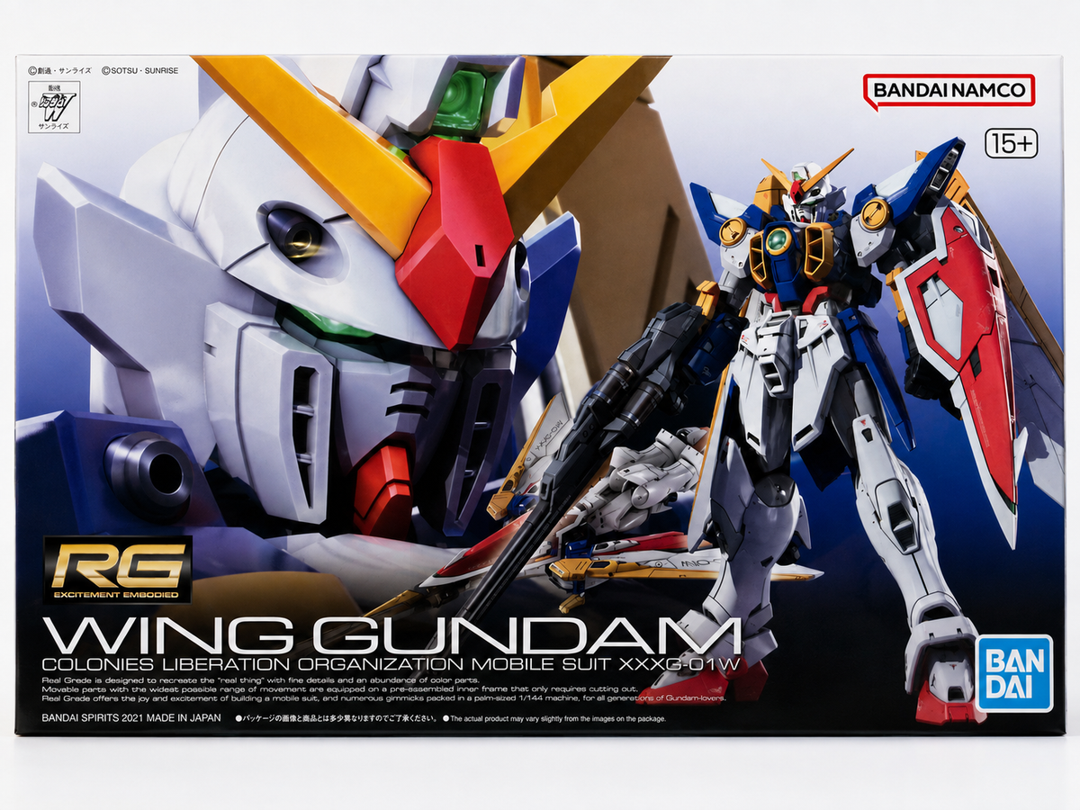 Box art for the Bandai Namco RG Wing Gundam model kit, showing a large close-up of the Gundam head on the left and the assembled blue, white, and red mobile suit on the right against a dark illustrated background.