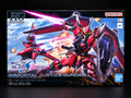 Bandai Namco HG Cosmebota G-Force Free Freedom Immortal Justice Gundam 1/14 scale model kit box, featuring a red and black mecha design with a pink beam saber against a blue sky and explosions.